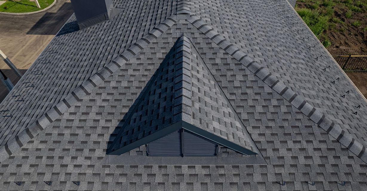 A drone is flying over a roof in a residential area.