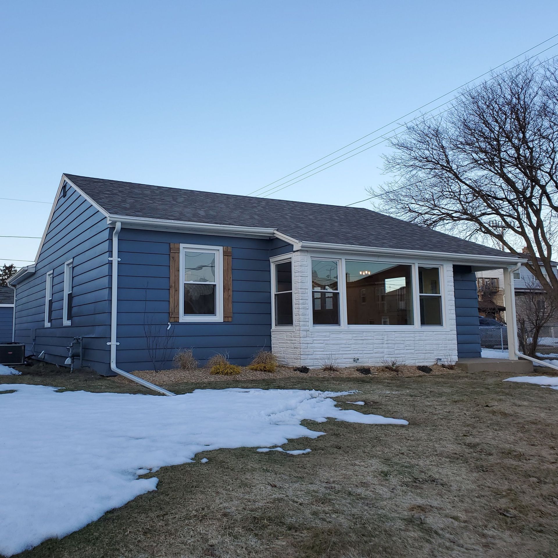 a white house with green siding and a gray roof