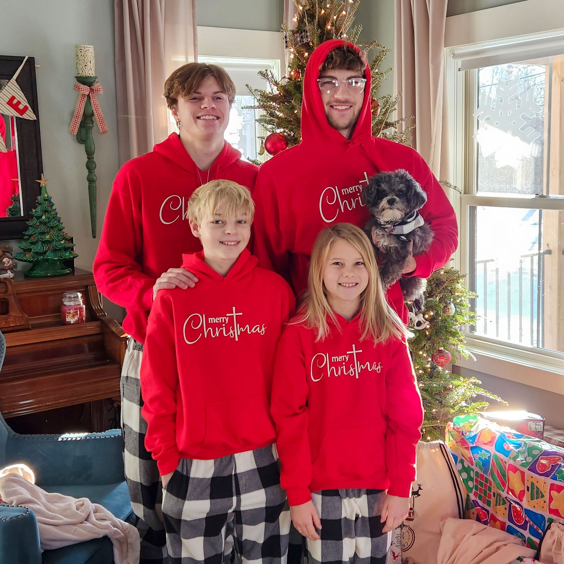 Advantage Matt's family is posing for a picture in front of a christmas tree.