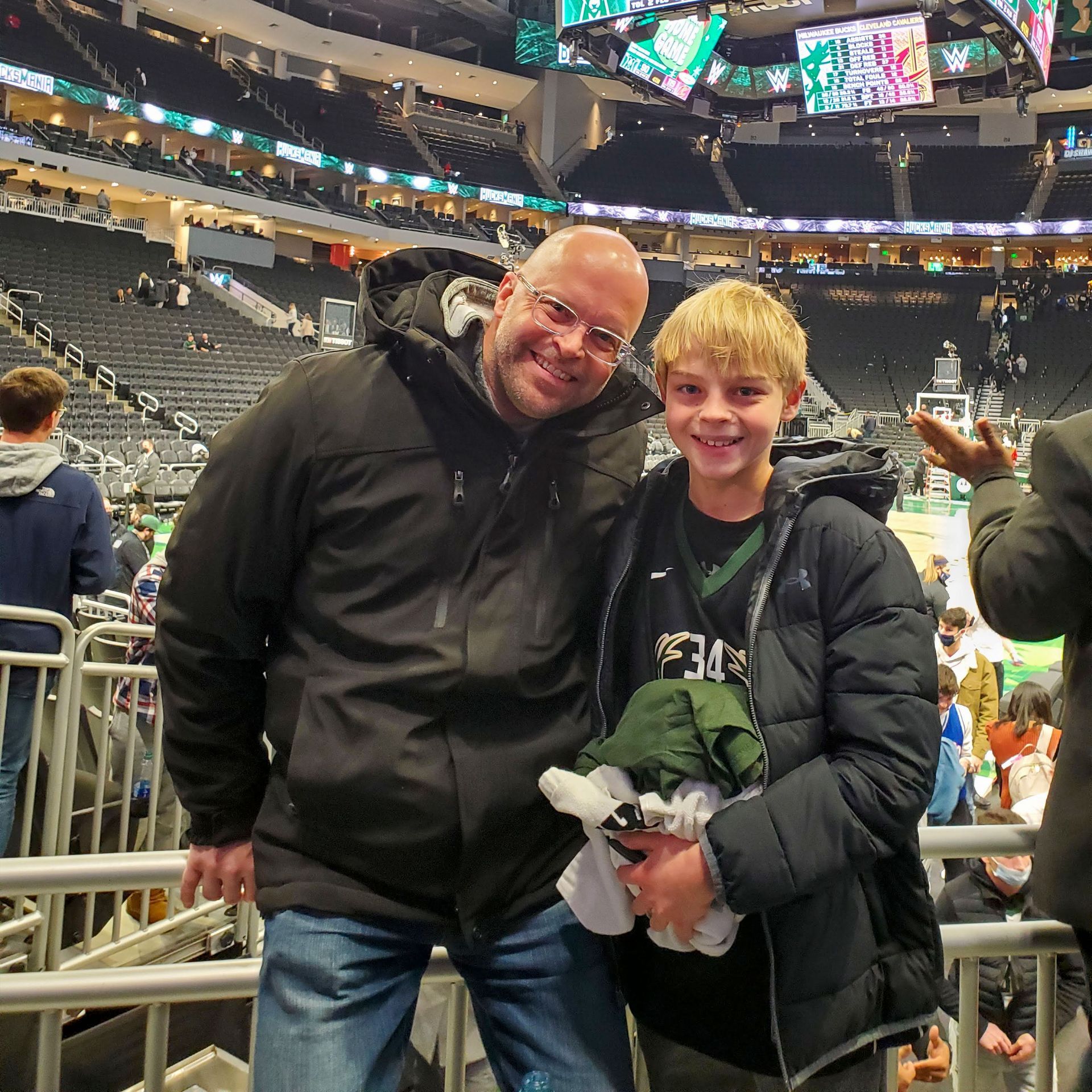 Advantage Matt Bruins  and a boy are posing for a picture in a stadium.