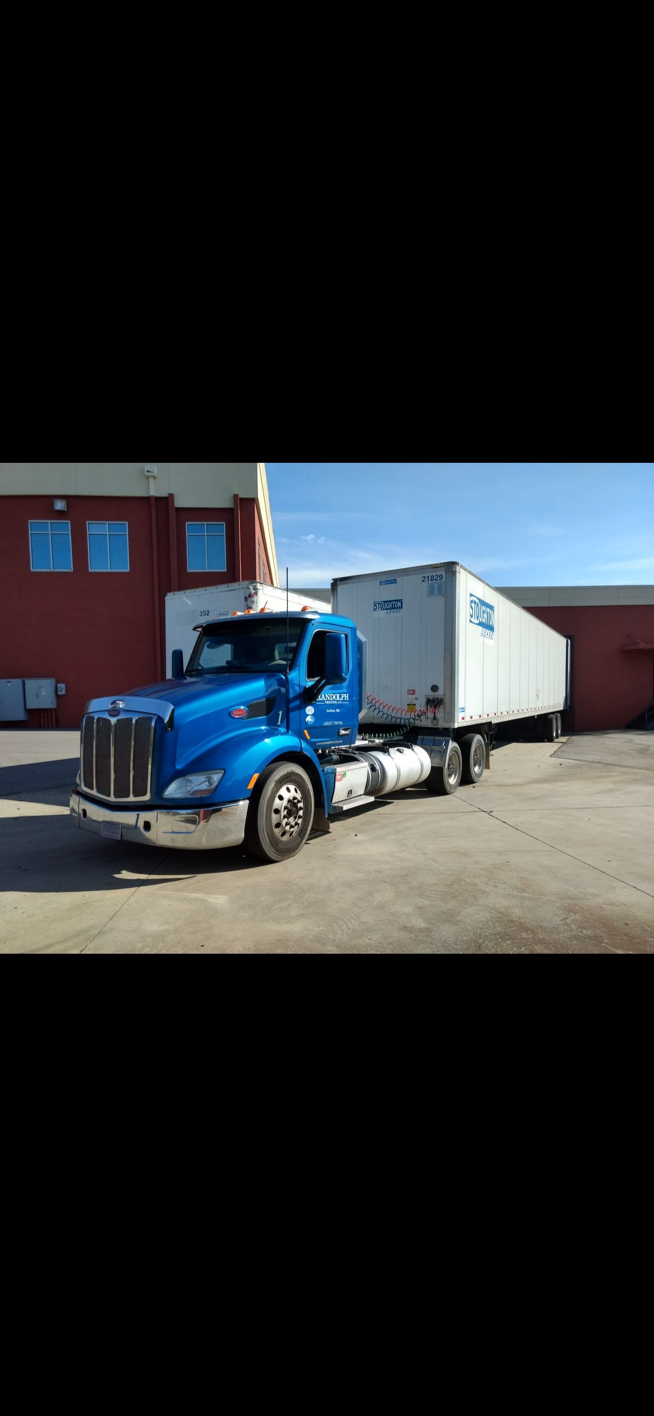 Blue semi-truck with an American flag painted on its bed.