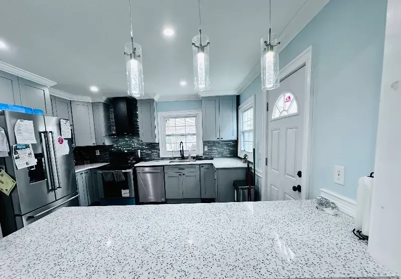 Kitchen with light gray cabinets, white countertops, and blue walls.