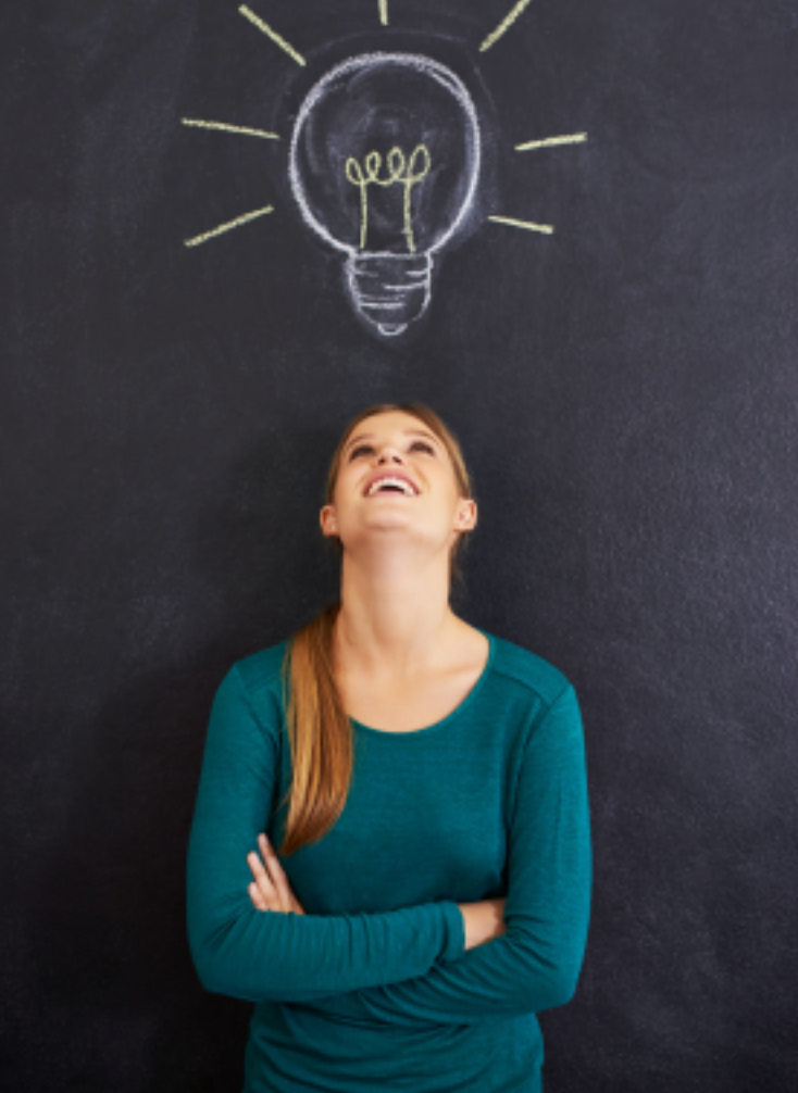 Child smiling with a chalk-drawn lightbulb above their head on a blackboard background.