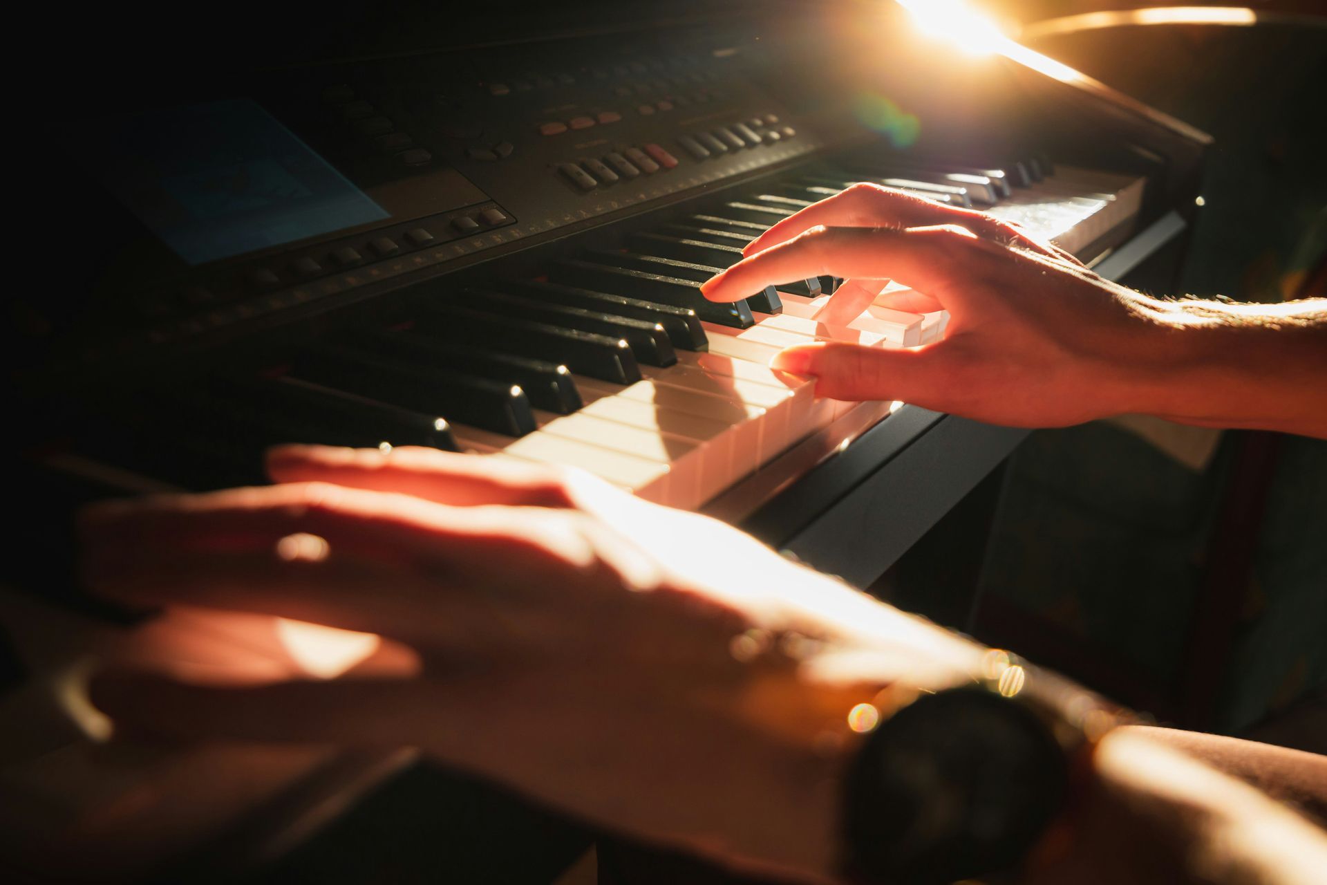 Close-up of hands playing piano keys.