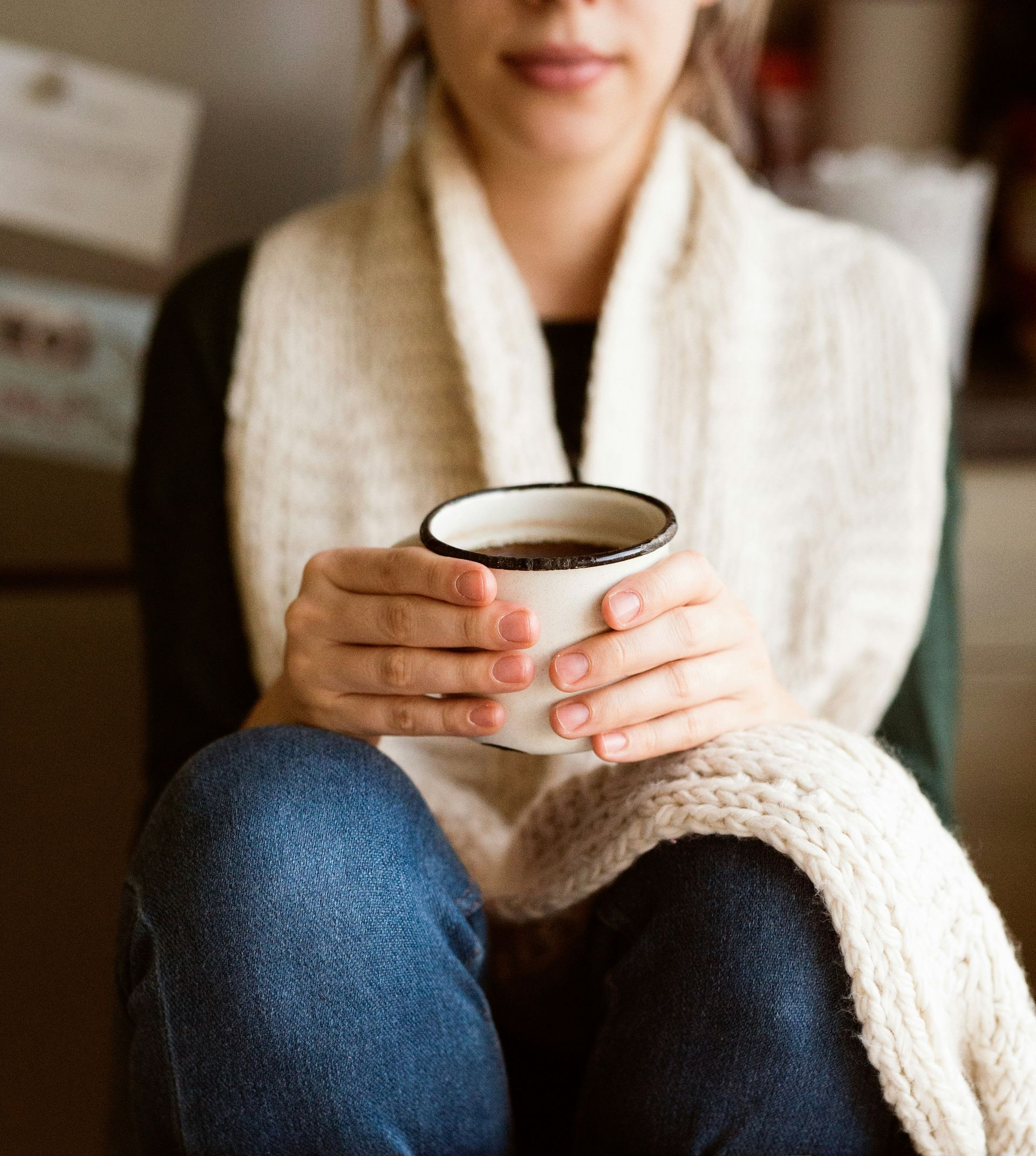 Hands holding a warm mug in a quiet moment of self-care during the holiday season.