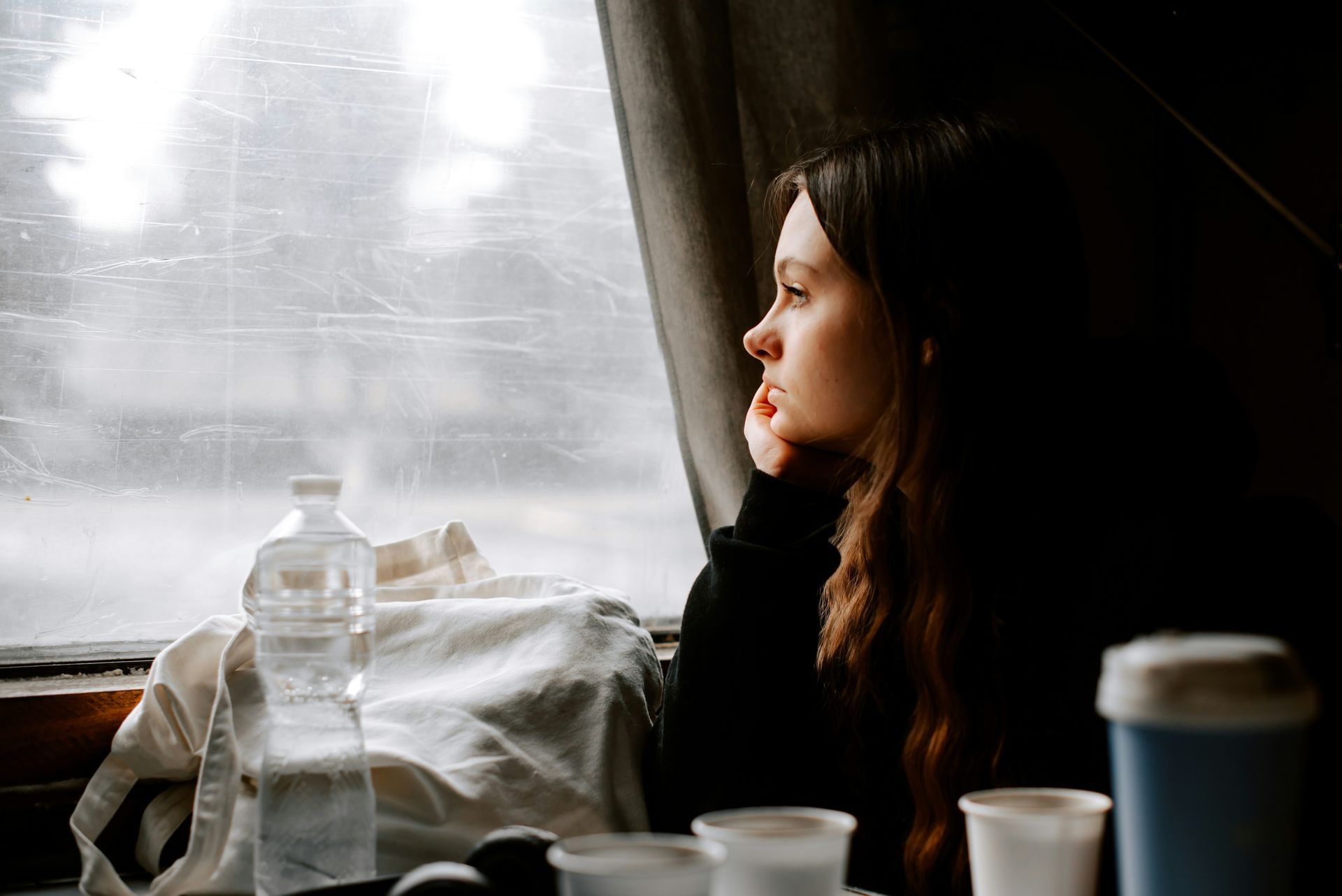 A woman looking thoughtfully out a train window after a difficult family gathering. The image represents recognizing unhealthy family relationship patterns, emotional reflection, and learning to trust yourself again.
