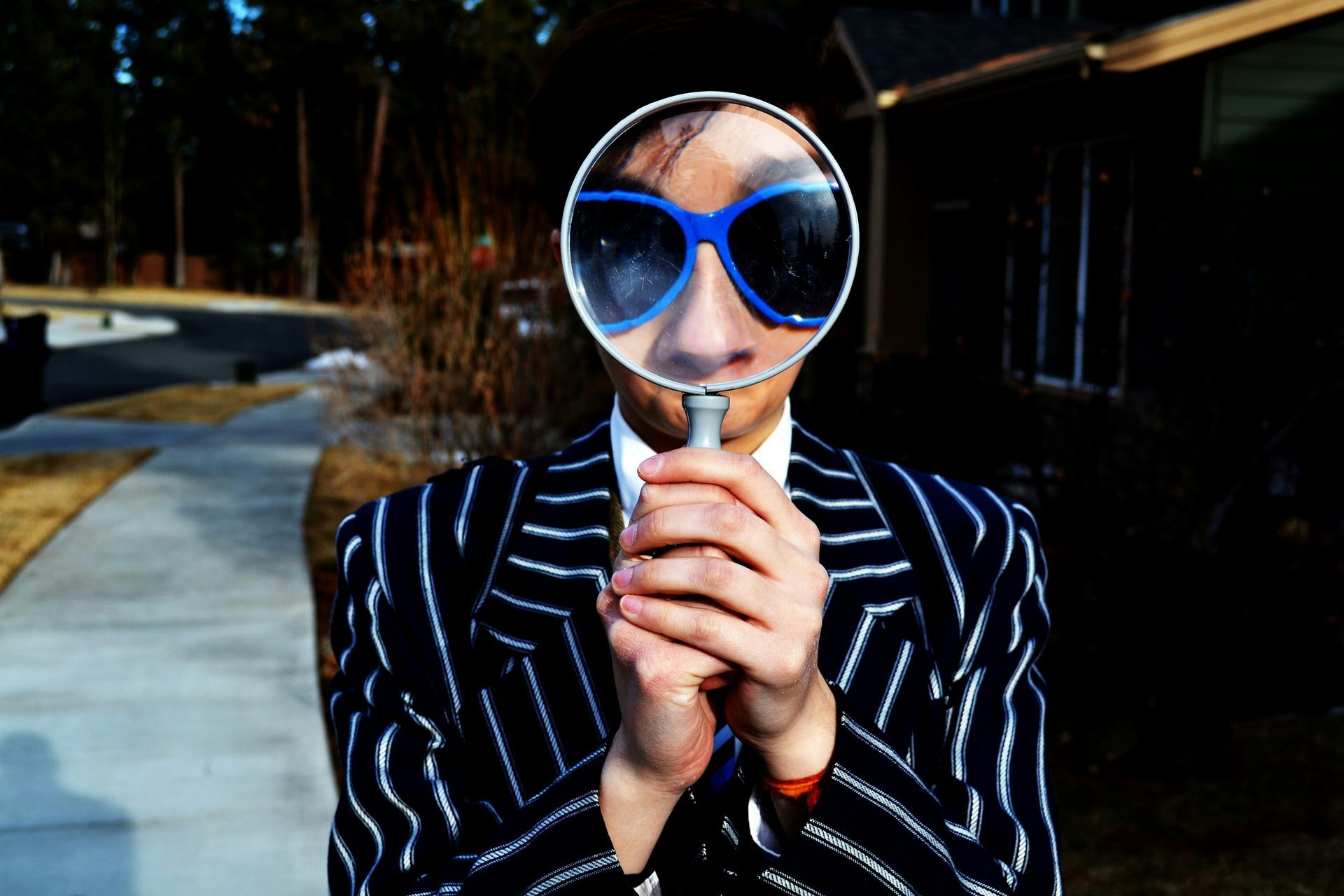 A person looking through a magnifying glass, representing hypervigilance and scanning for subtle signs of disconnection