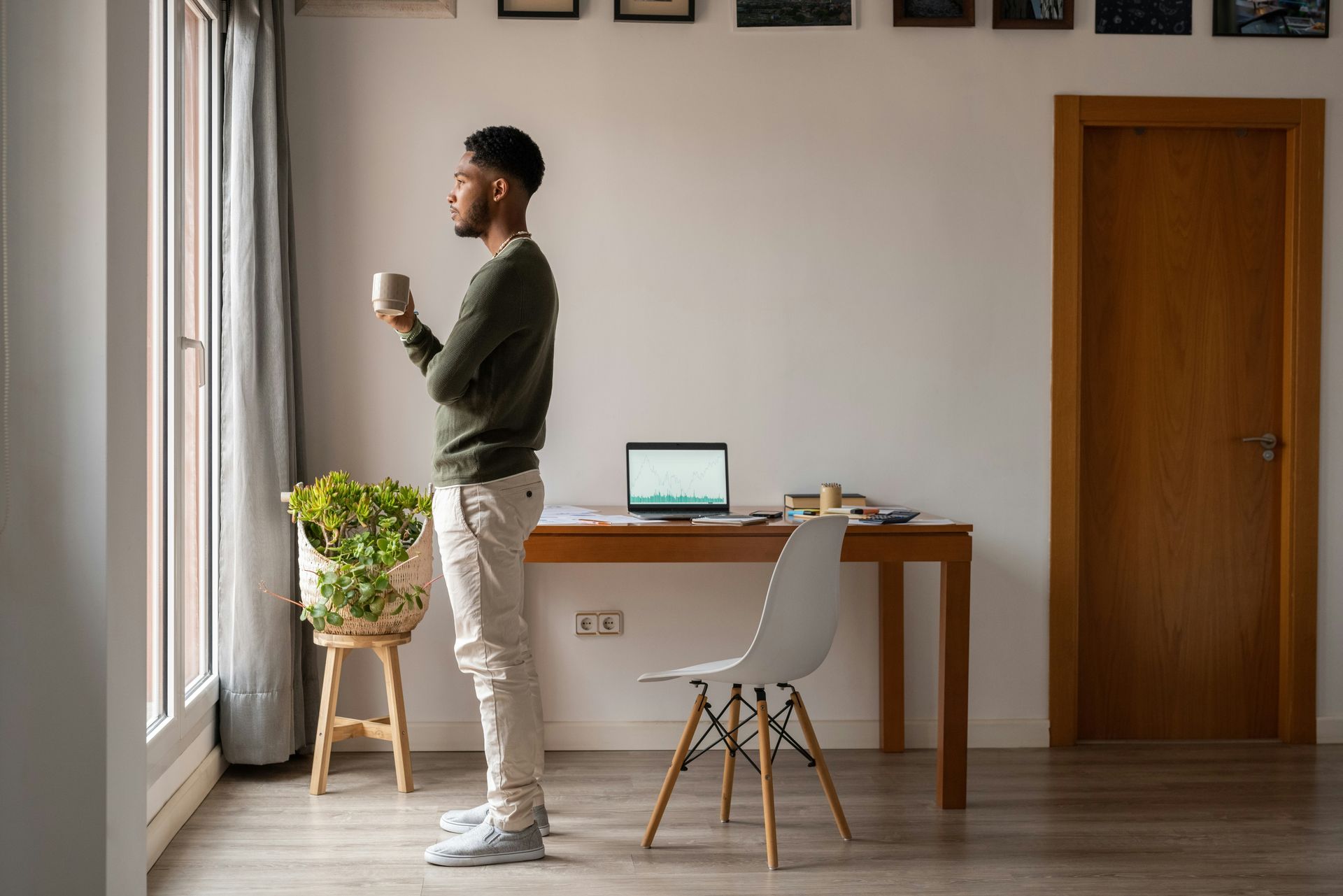 Person standing by a window, thinking
