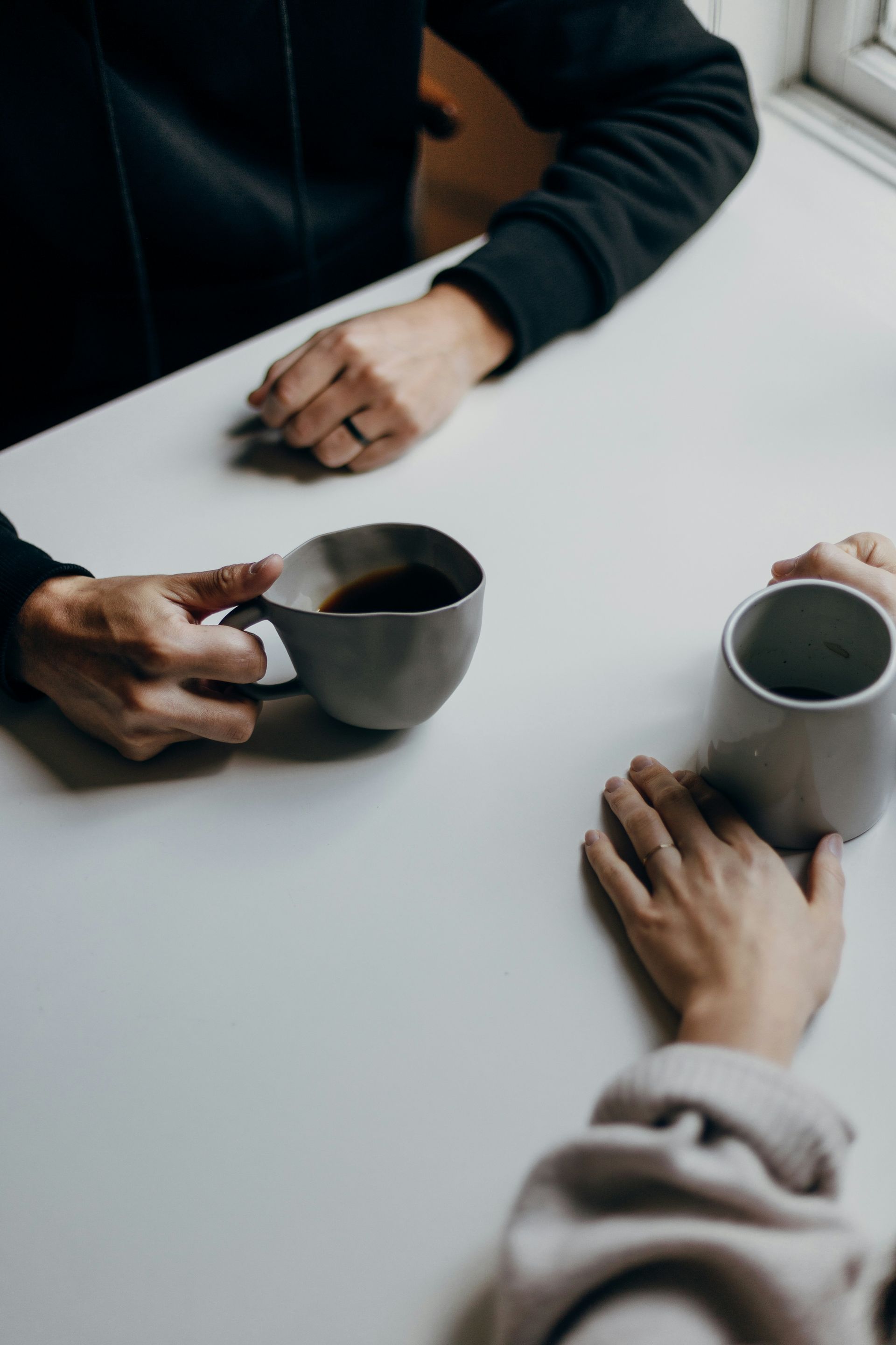 Two people sharing an honest conversation over coffee symbolize emotional connection and understanding.