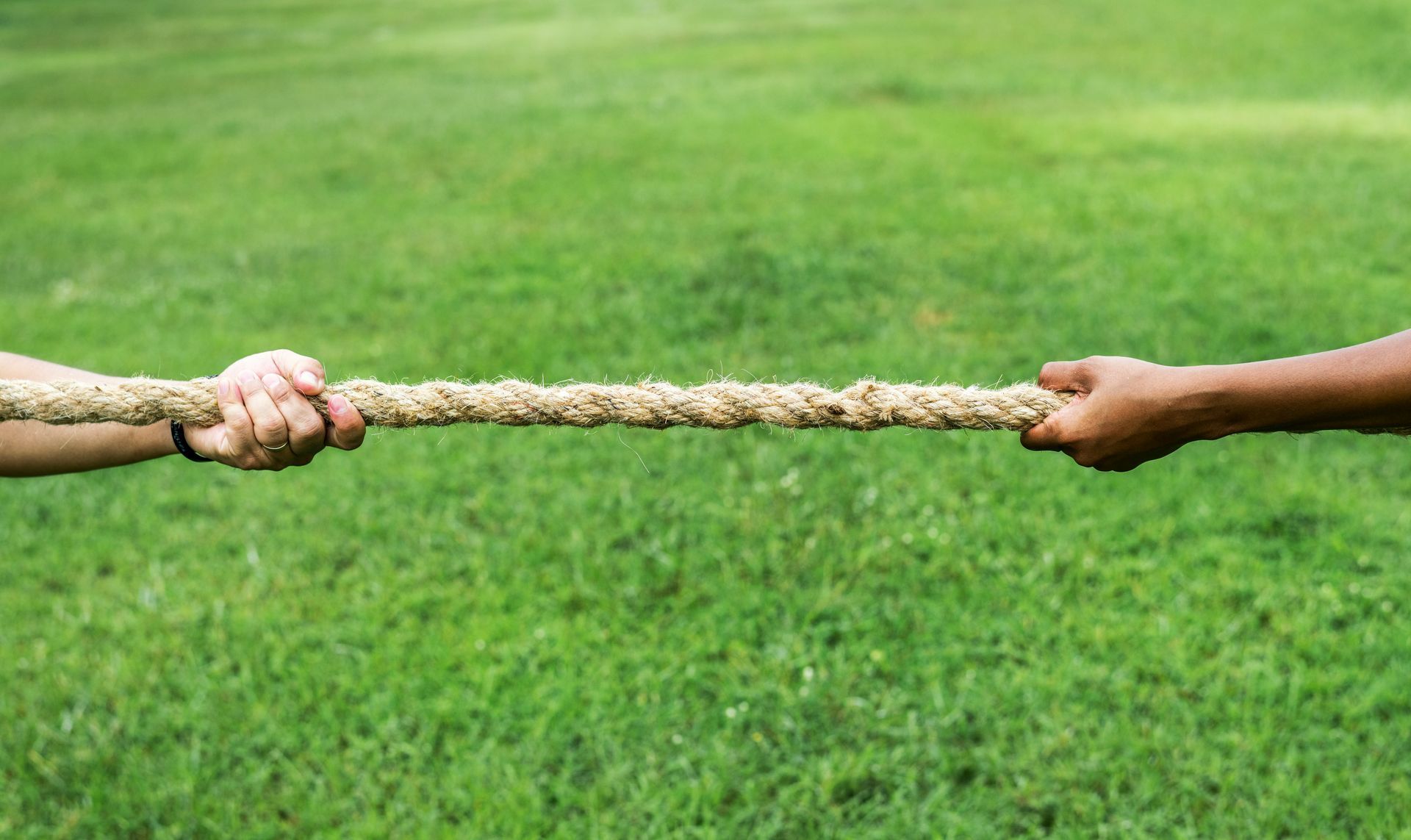 Two hands pulling on a rope from opposite directions, representing the tension of a trauma bond.