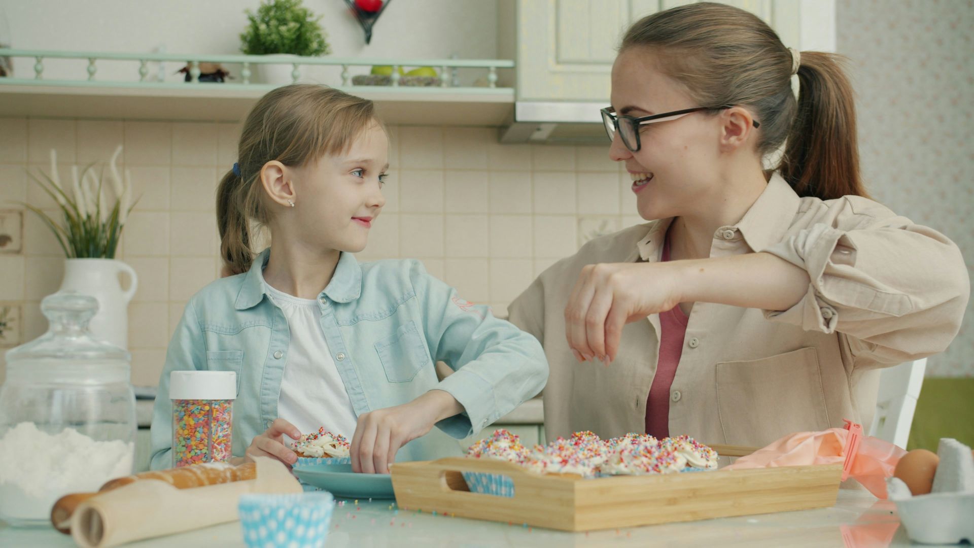 Mother and daughter baking together in the kitchen, showing a warm, connected relationship and healthy attachment.