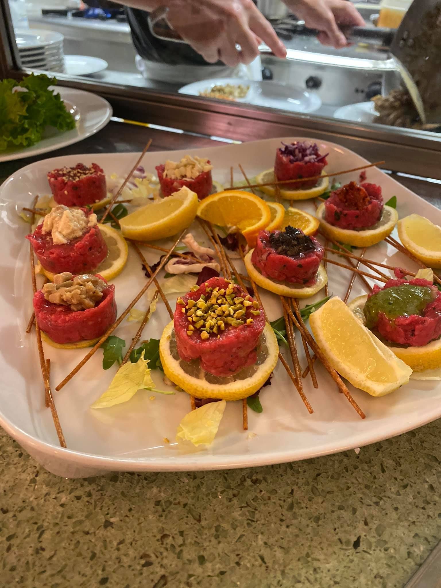 Un piatto bianco sormontato da una varietà di cibi e fette di limone.
