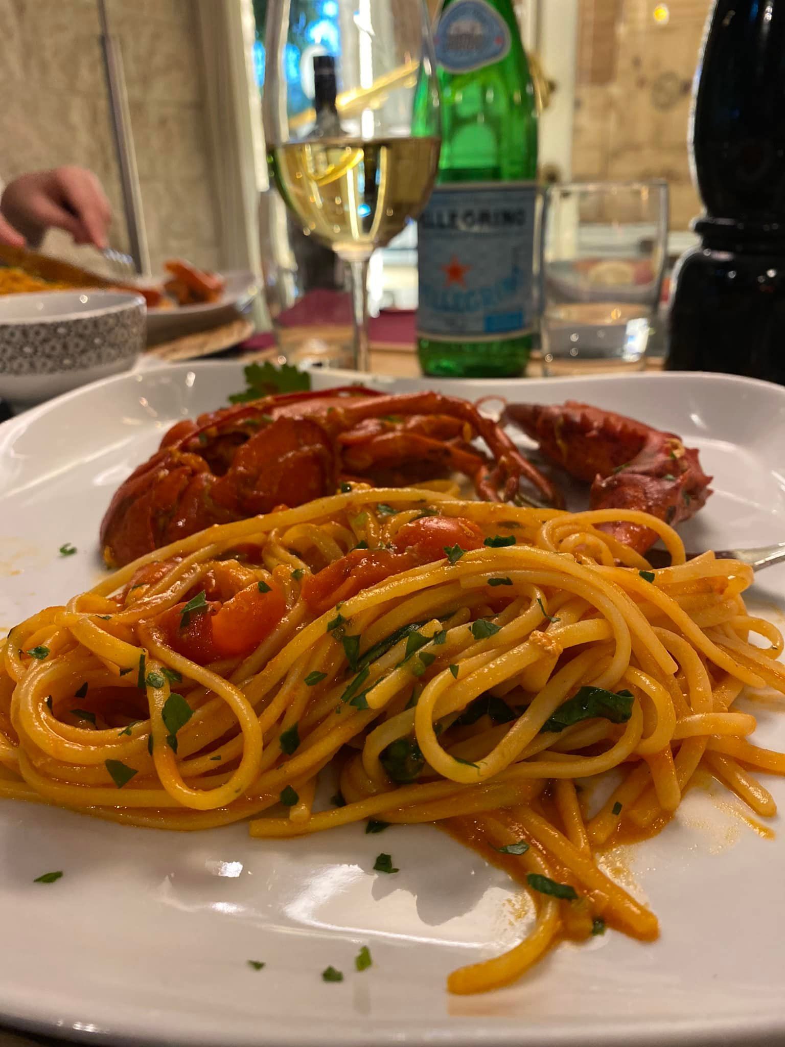 Un piatto di spaghetti con sopra un granchio.