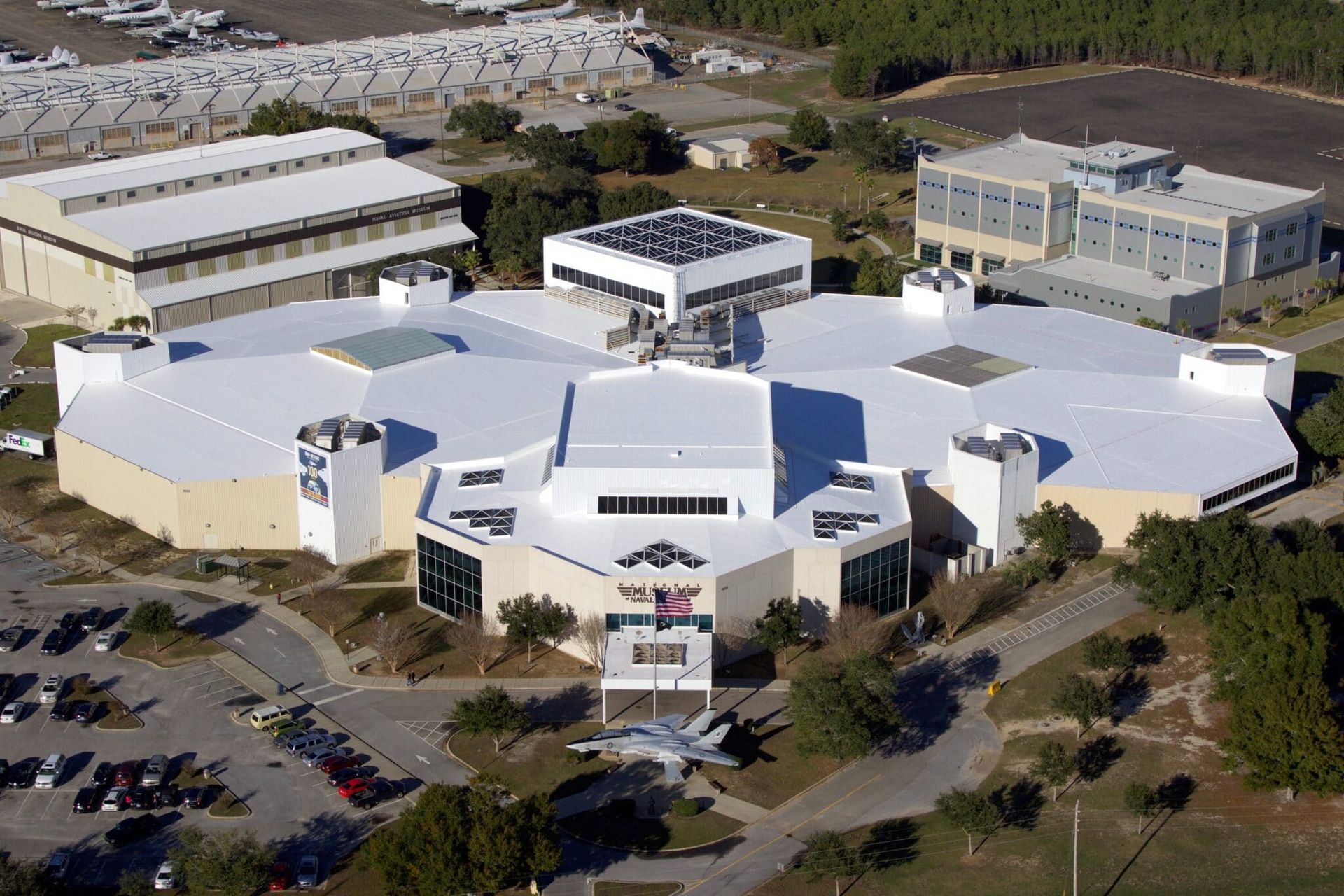 An aerial view of a large building with a white roof