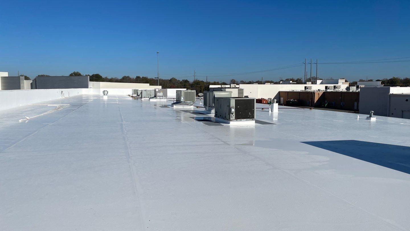 A white roof with a lot of air conditioners on it.