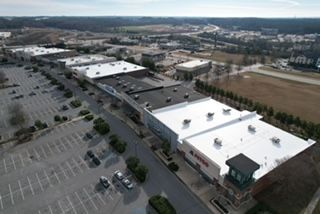 An aerial view of a shopping center with a white roof.