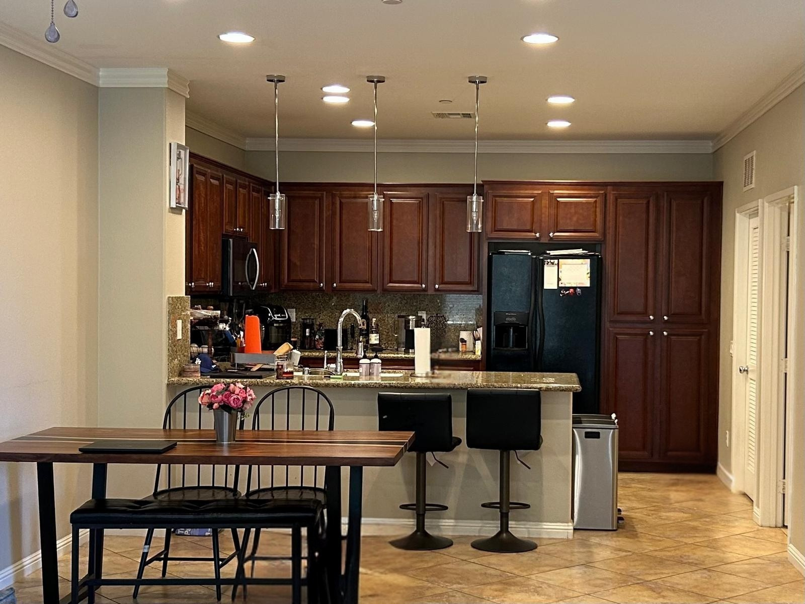 A kitchen with a table and chairs and a refrigerator