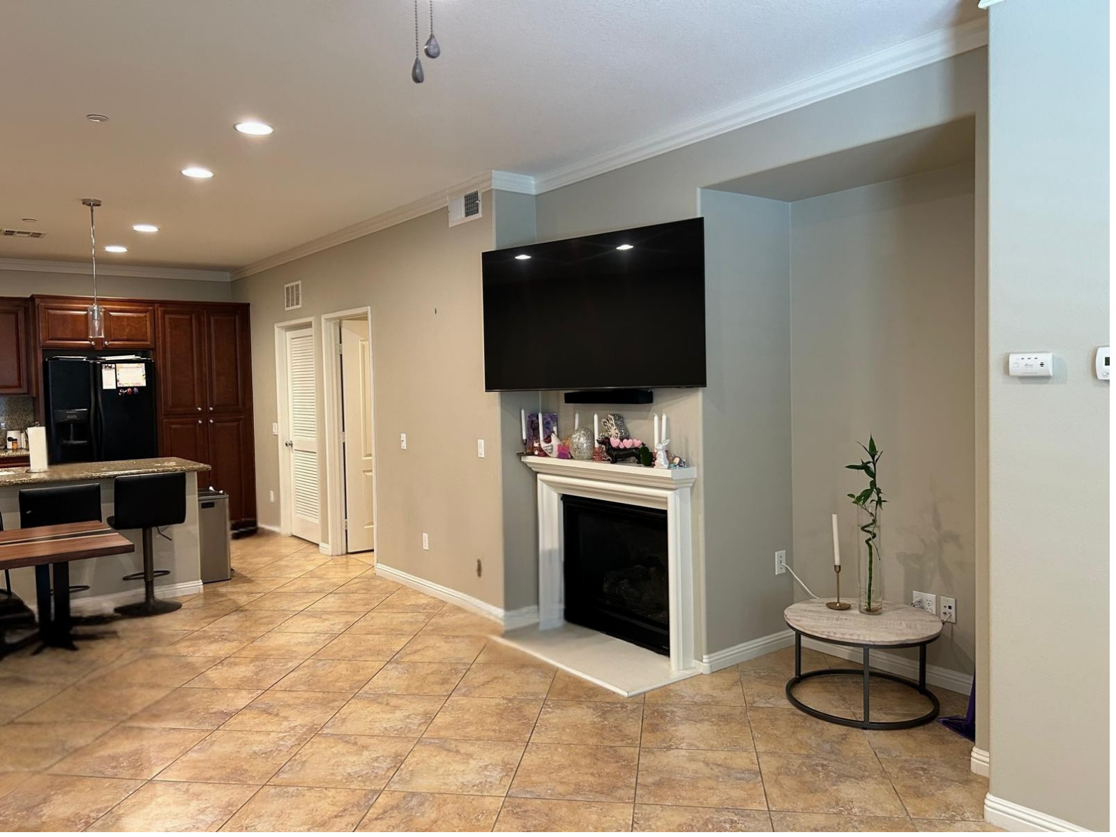A living room with a fireplace and a flat screen tv on the wall.