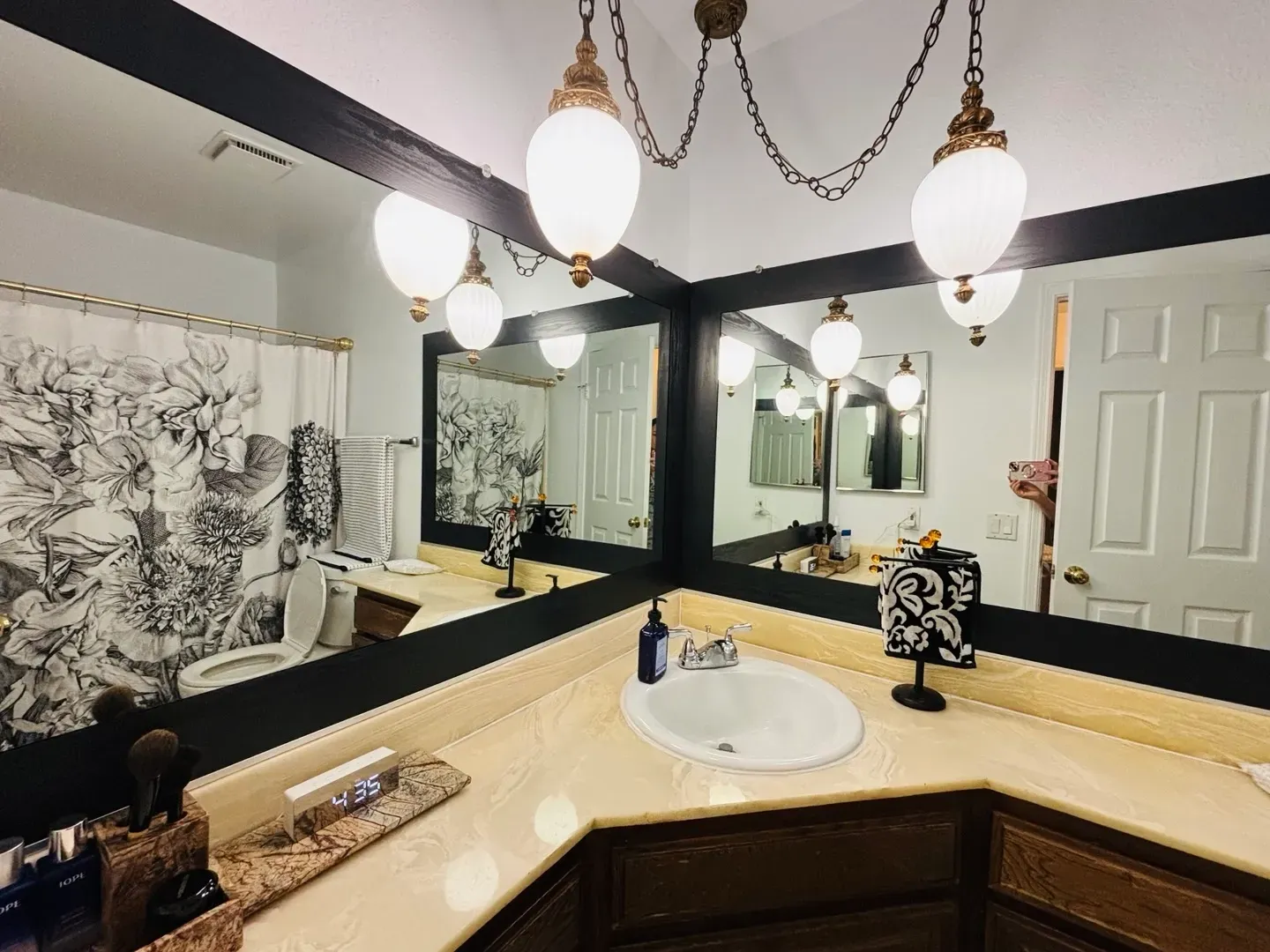 A bathroom with two mirrors , a sink and a toilet.