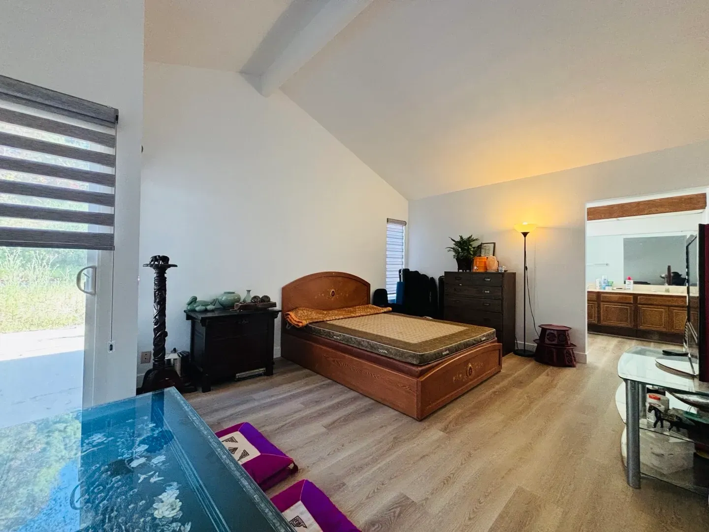 A bedroom with a bed , dresser , nightstand and television.