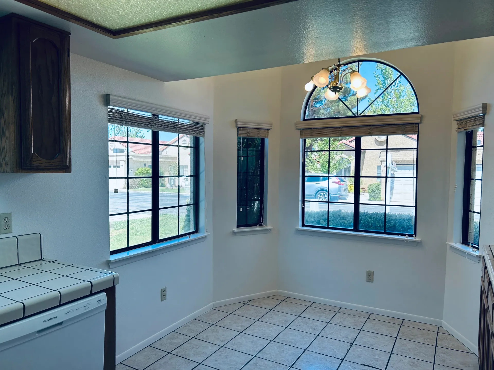 A kitchen with a lot of windows and a tiled floor.