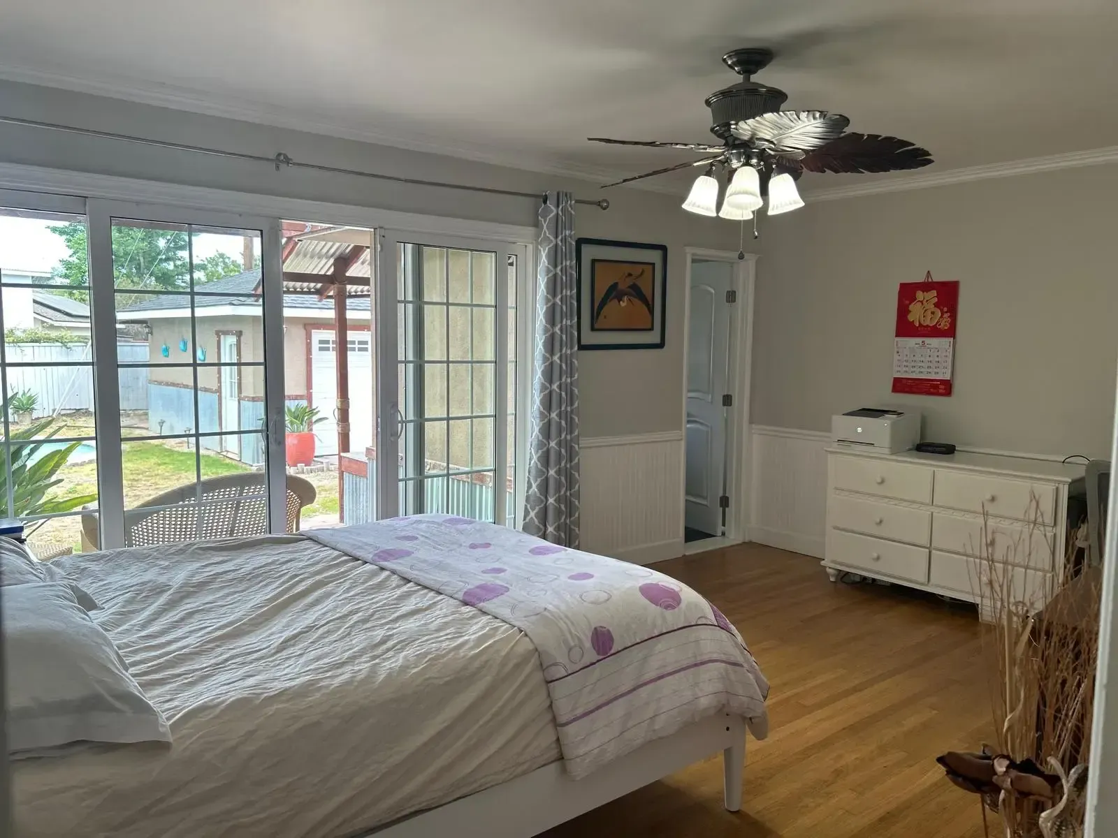 A bedroom with a bed and a ceiling fan