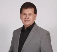 A man in a suit and black shirt smiles for the camera Samuel Gonzalez