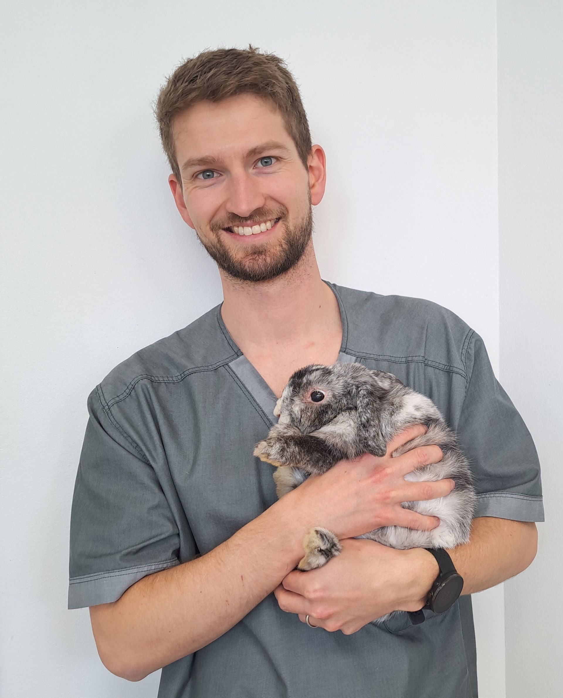 Un homme tient un petit lapin dans ses bras.