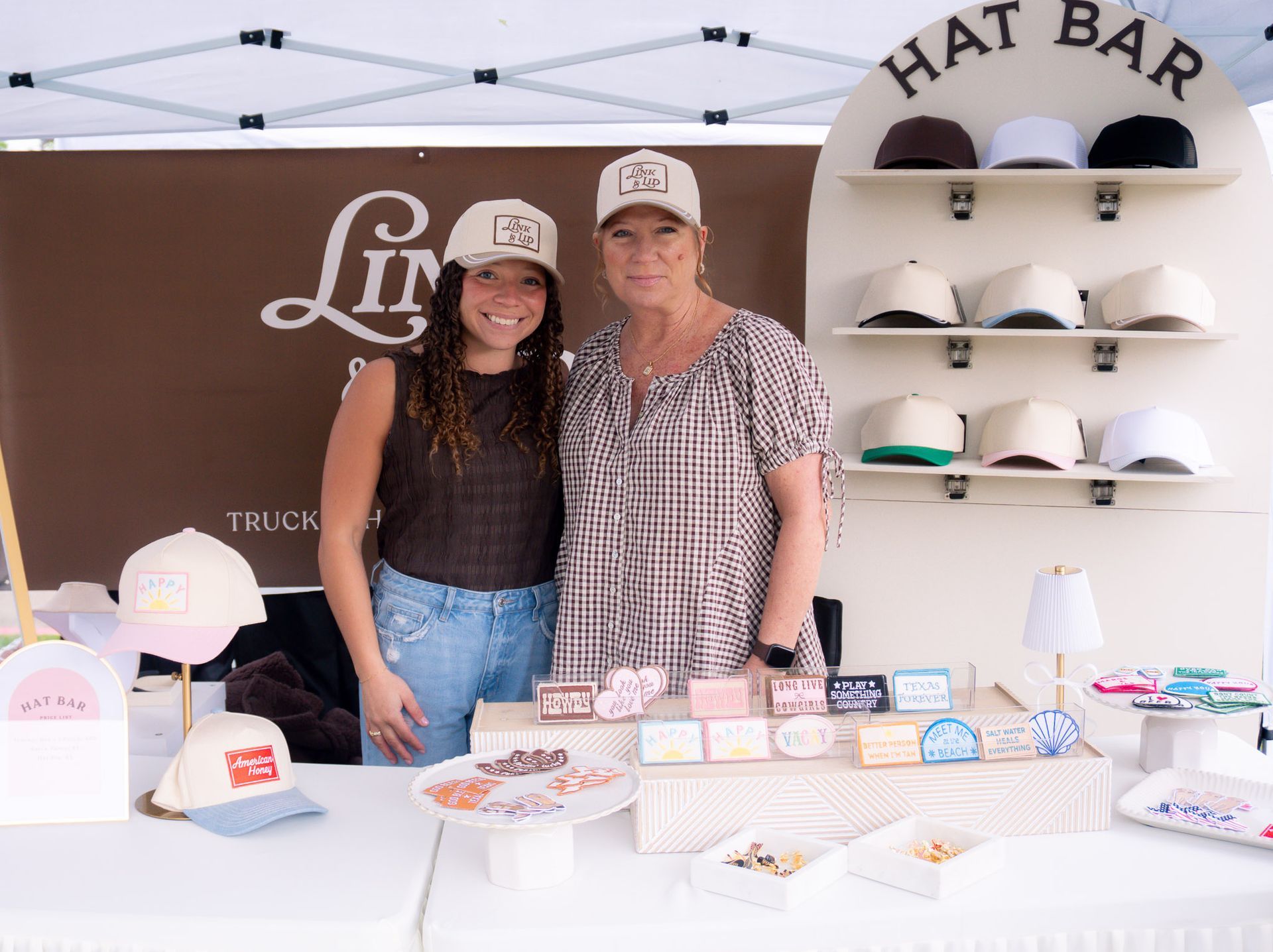 Link and Lid, custom hat and charm bar, booth set up at a local artisan pop-up market in DFW.