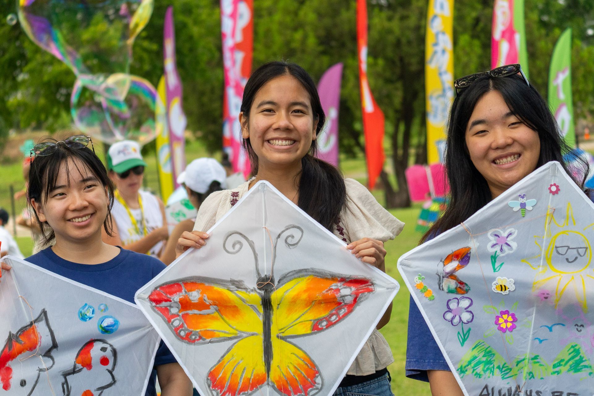 Volunteer helping a guest prepare a decorated kite during the Avy's Sunshine Kite Festival in Dallas.