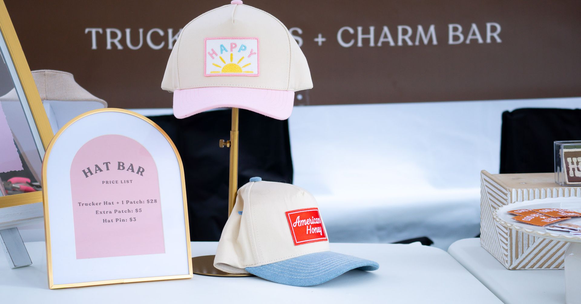 Link & Lid custom hat bar display featuring personalized hats, branding, and charm bar setup at a local market.