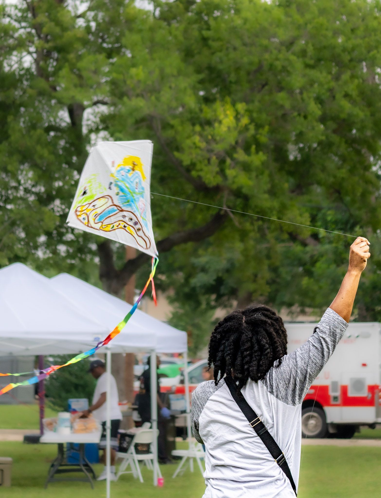 Person flying a decorated kite during the Avy's Sunshine Kite Festival in Dallas.