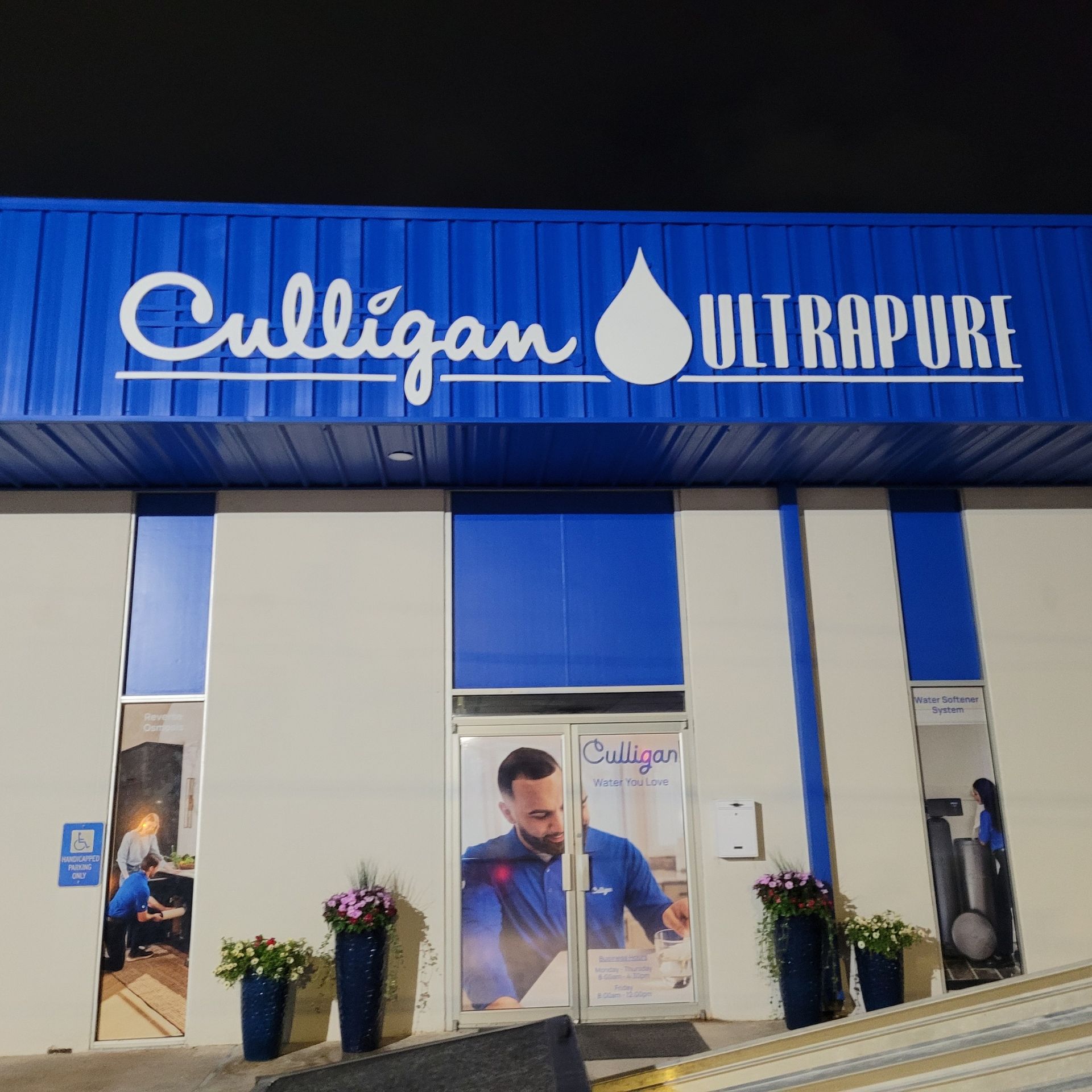 Culligan Ultrapure storefront with blue signage and doors, potted plants at the entrance