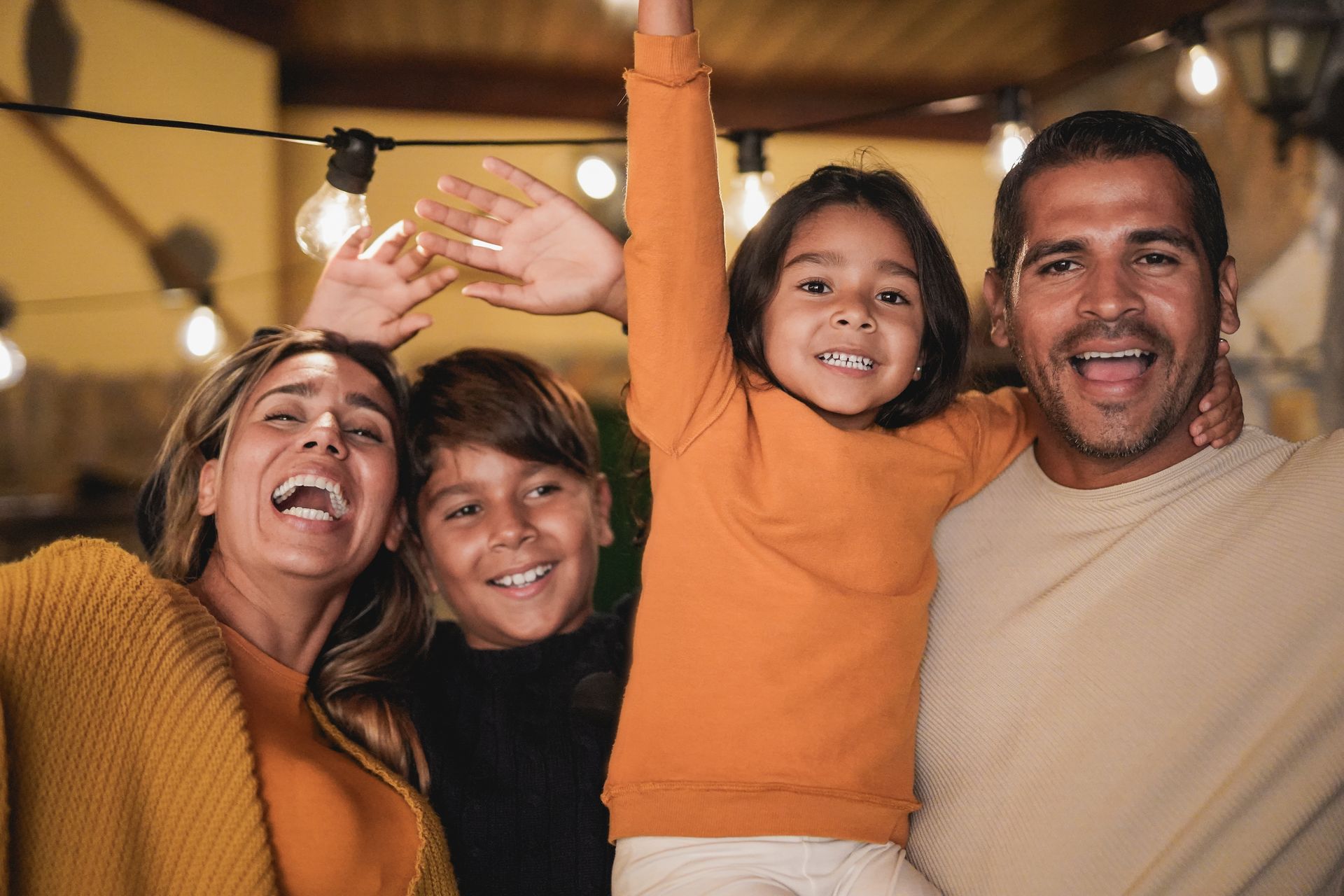 A family is posing for a picture with their hands in the air.
