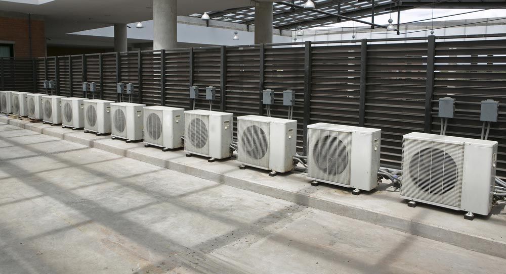 A Row of White Outdoor Air Conditioning Units — Premiair Refrigeration, Air Conditioning & Electrical in Tamworth, NSW