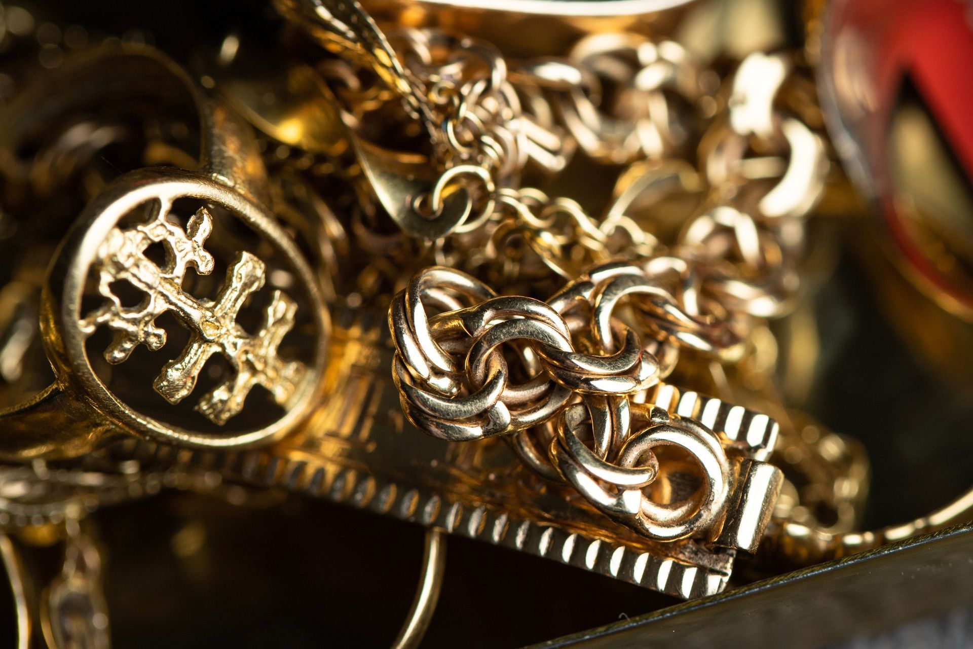 A pile of gold rings, chains, and a watch is arranged for jewelry evaluation.