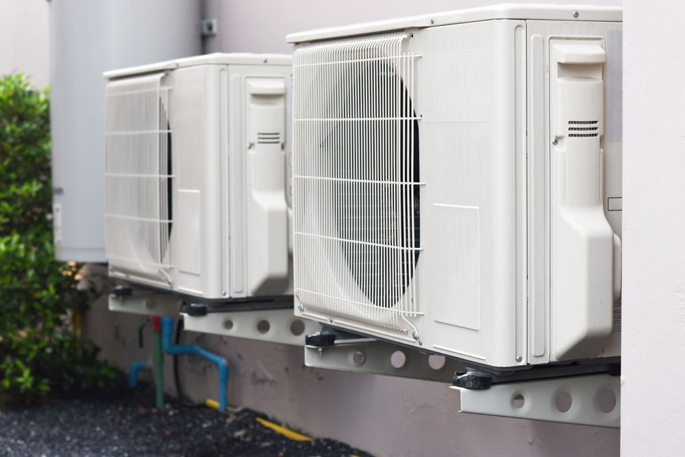 Three Air Conditioners Are Mounted on the Side of a Building — Enterprise Air That's Cool in Bargara, QLD