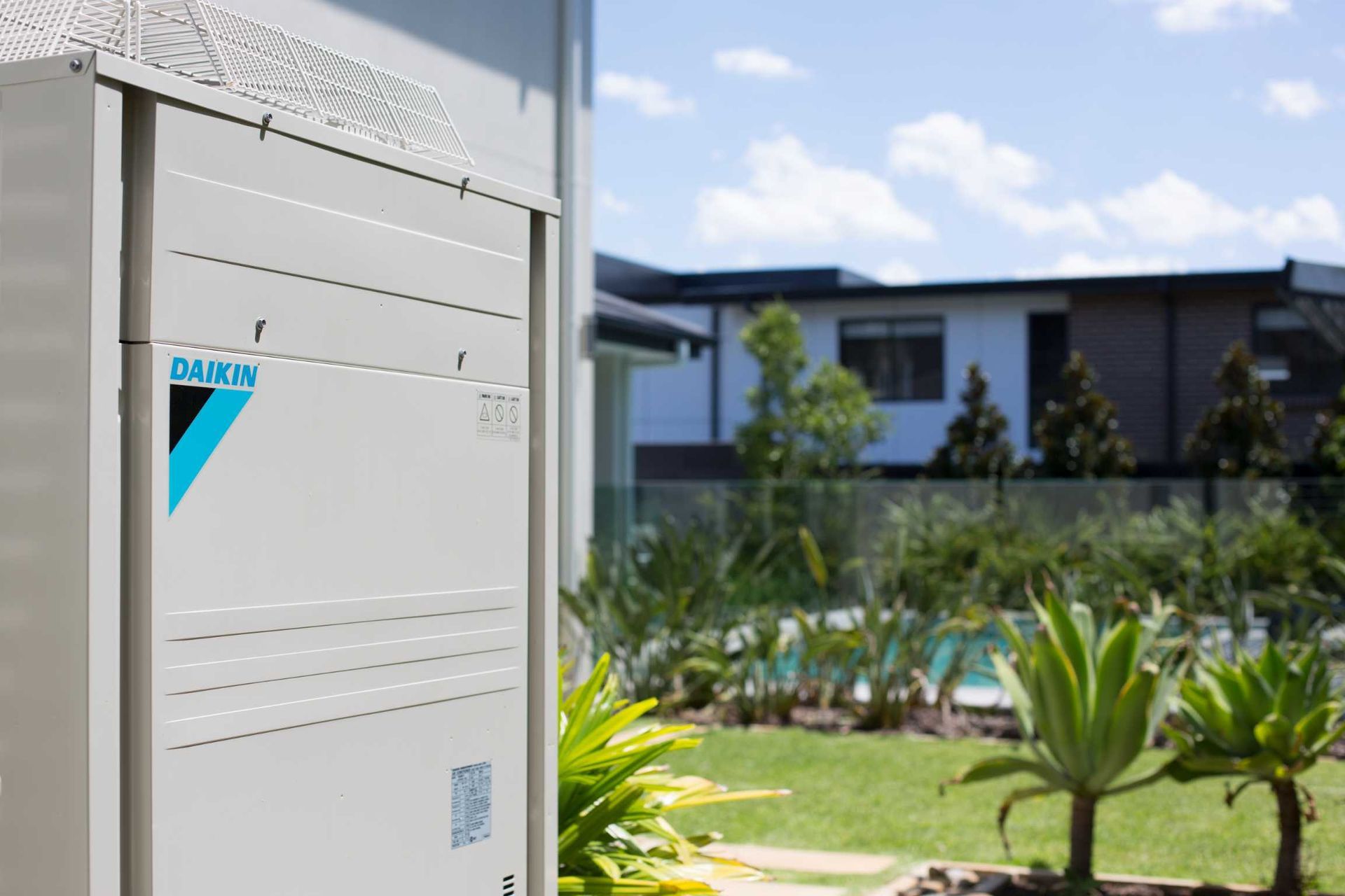 A Daikin Air Conditioner is Sitting Outside of a House — Enterprise Air That's Cool in Svensson Heights, QLD