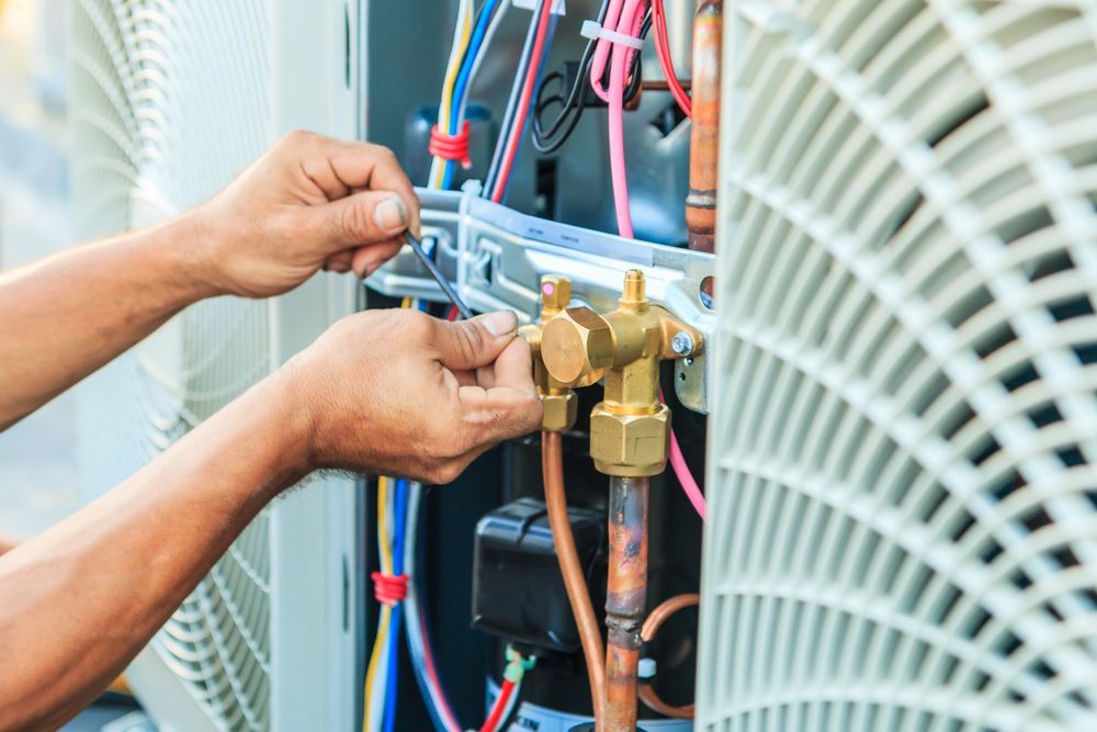A Man is Working on an Air Conditioner With a Wrench — Enterprise Air That's Cool in Svensson Heights, QLD