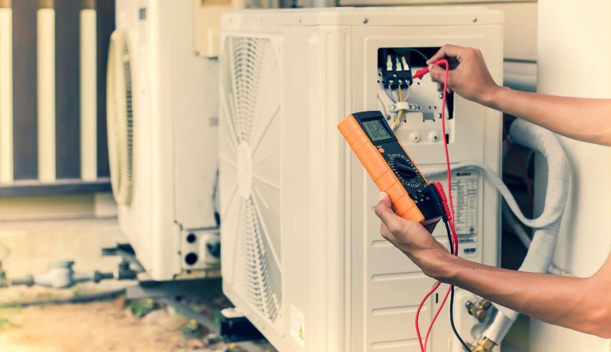A Man is Using a Multimeter to Test an Air Conditioner — Enterprise Air That's Cool in Bullyard, QLD