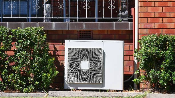 A White Air Conditioner is Sitting on the Side of a Brick Building — Enterprise Air That's Cool in Avenell Heights, QLD