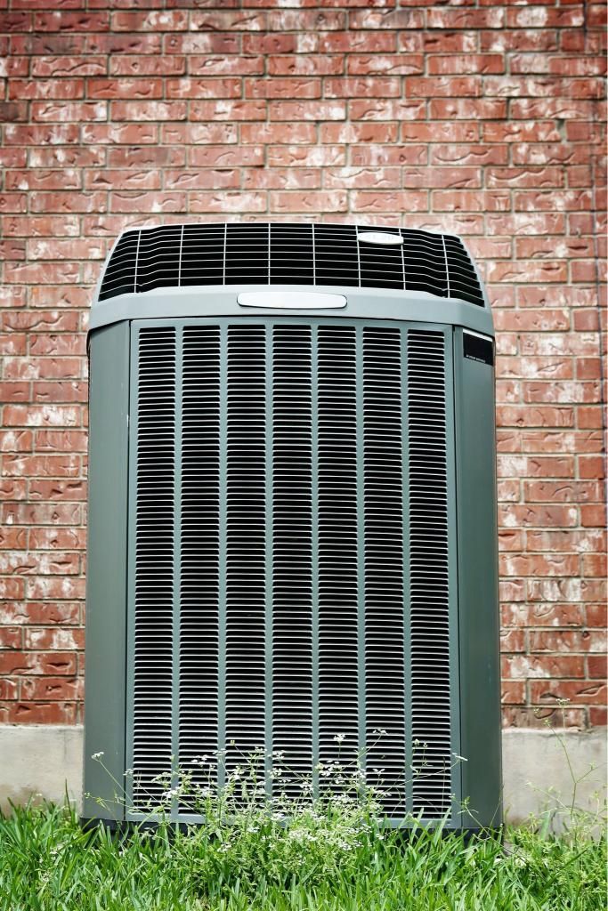 A Large Air Conditioner is Sitting on the Side of a Brick Building — Enterprise Air That's Cool in Gin Gin, QLD