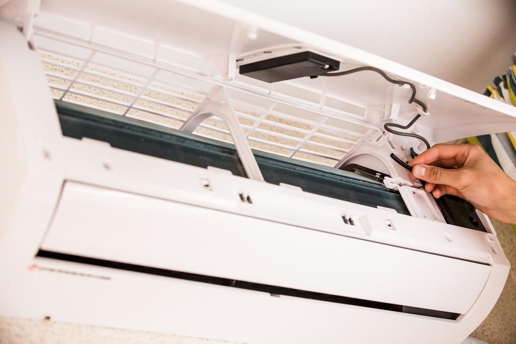 A Person is Cleaning an Air Conditioner — Enterprise Air That's Cool in Svensson Heights, QLD