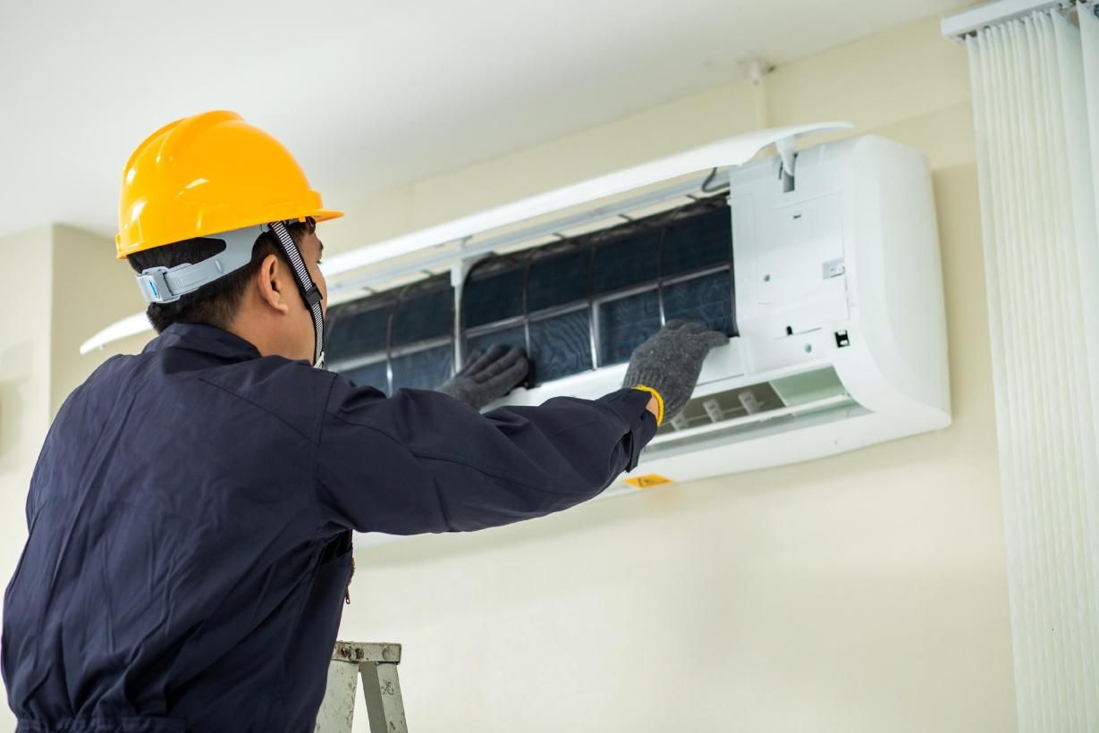 A Man is Working on an Air Conditioner on a Ladder — Enterprise Air That's Cool in Innes Park, QLD