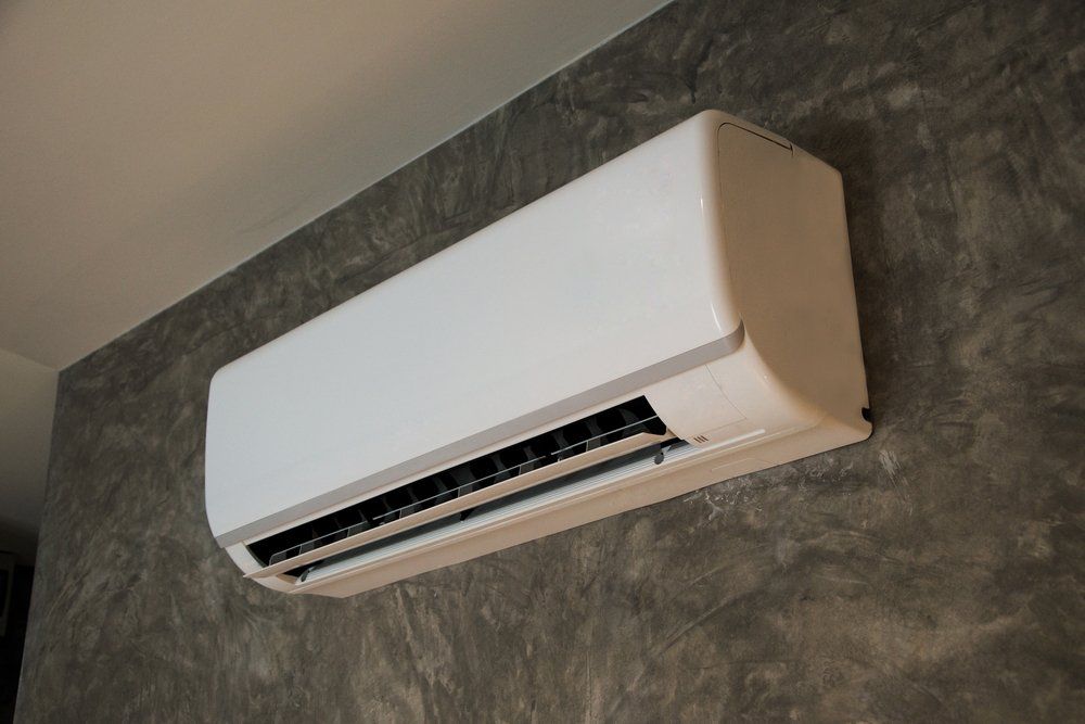 A White Air Conditioner is Hanging on a Concrete Wall — Enterprise Air That's Cool in Mon Repos, QLD