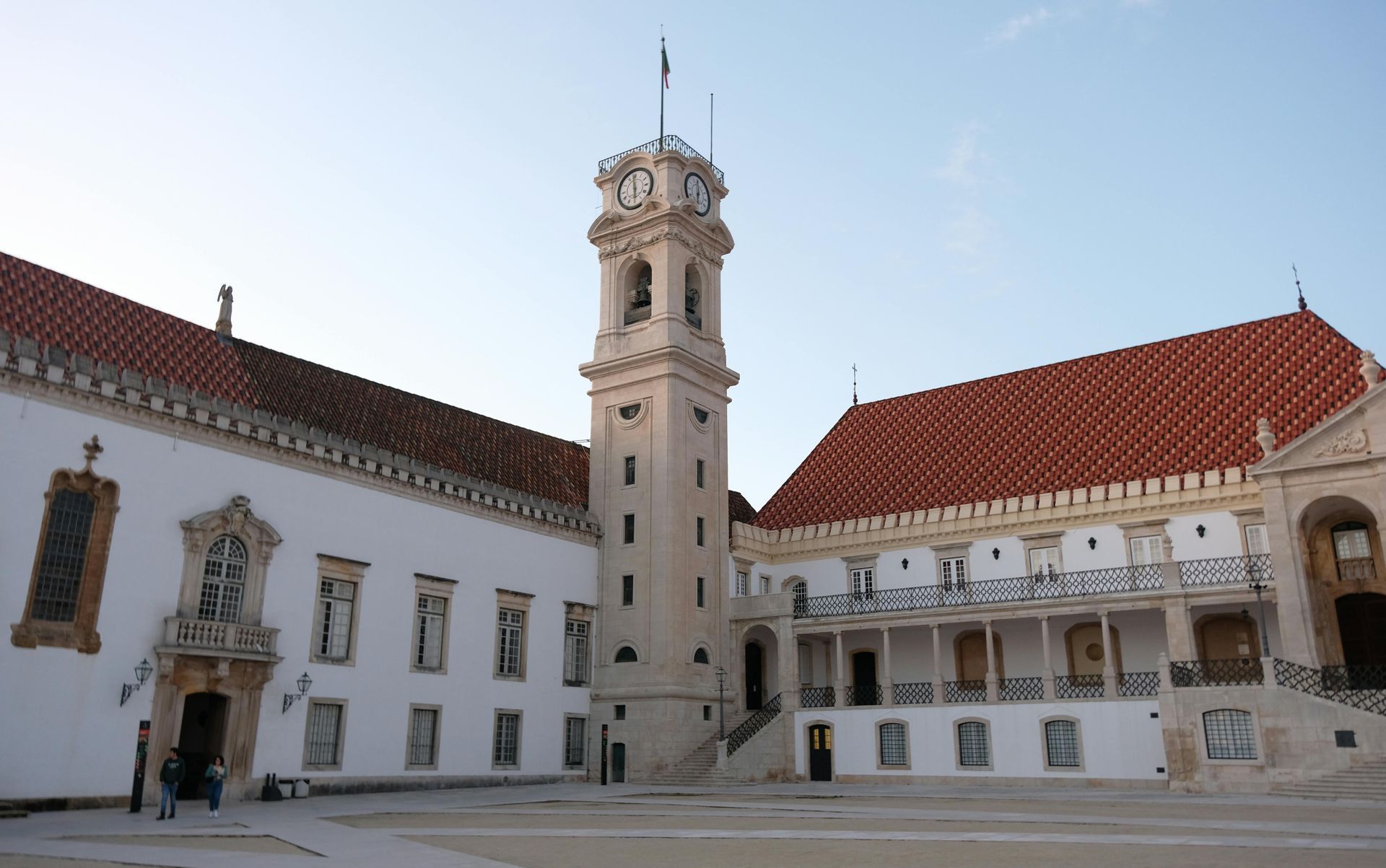 The famous and historical university of Coimbra with a red tiled roof and a clock tower