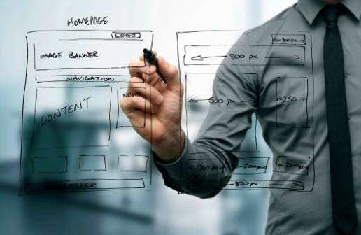 A person in a professional shirt and tie draws website wireframes on a glass board.