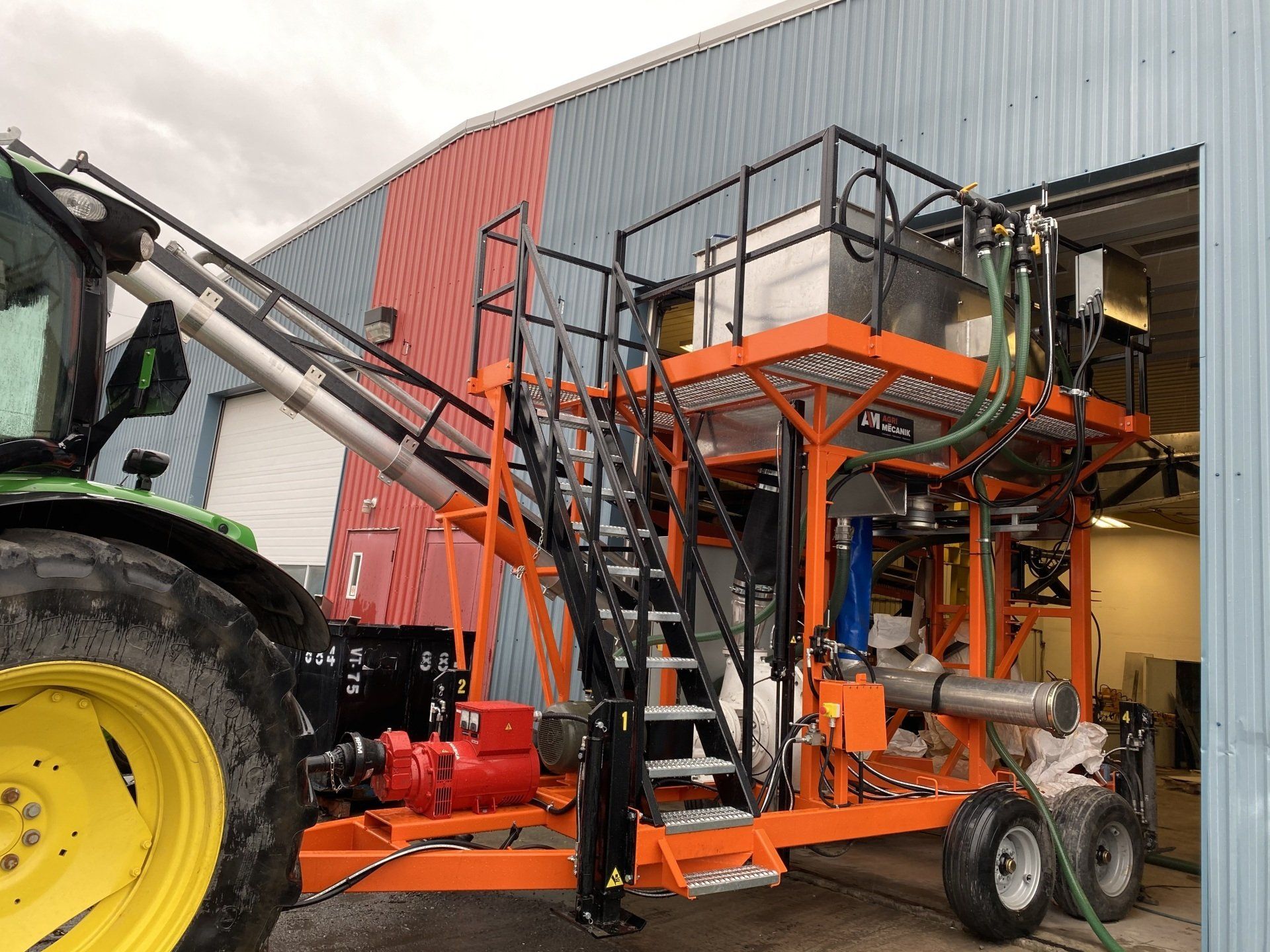 Un tracteur est garé devant un bâtiment avec une machine dessus.