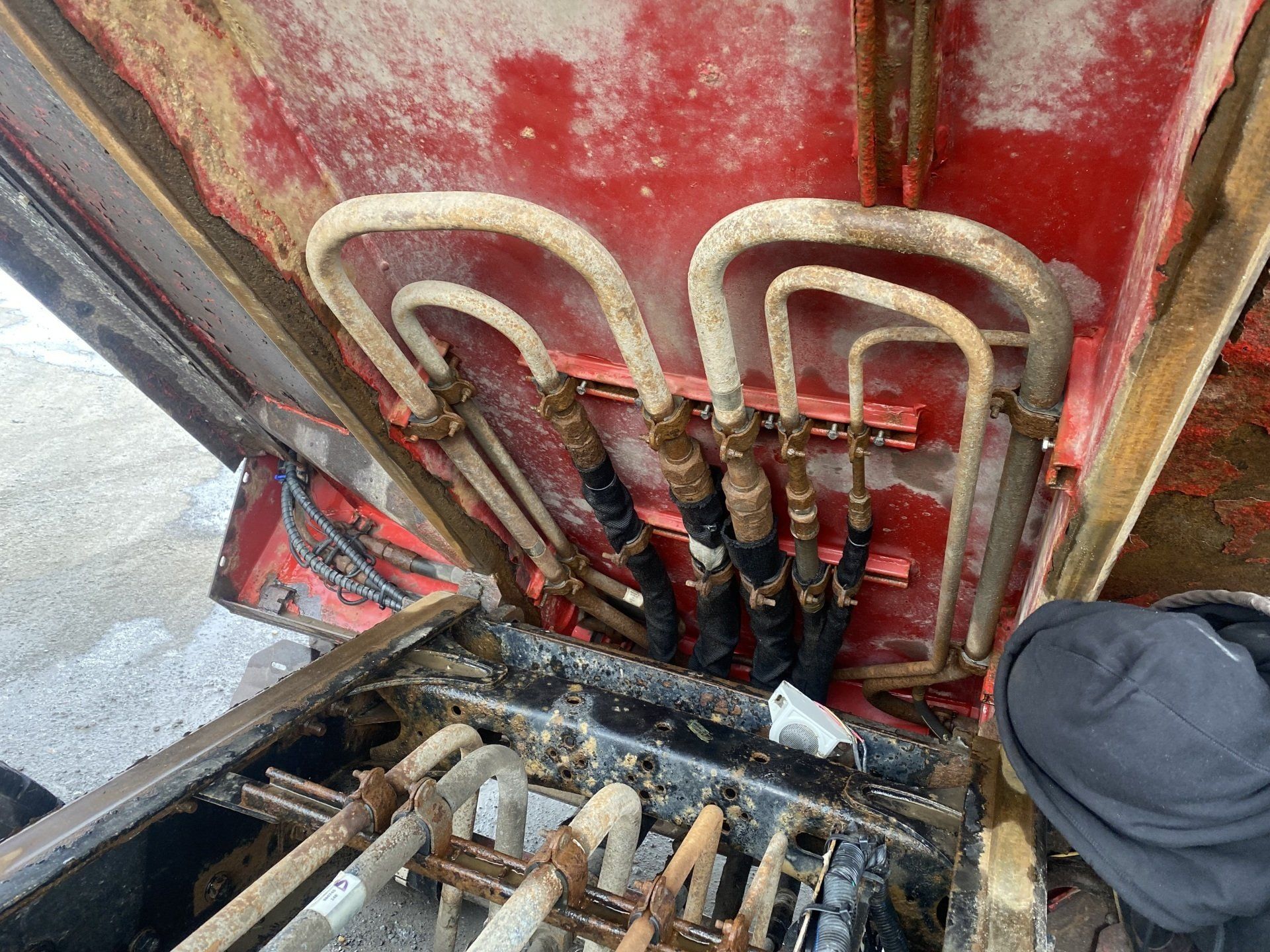 Une personne regarde sous le capot d’un tracteur.