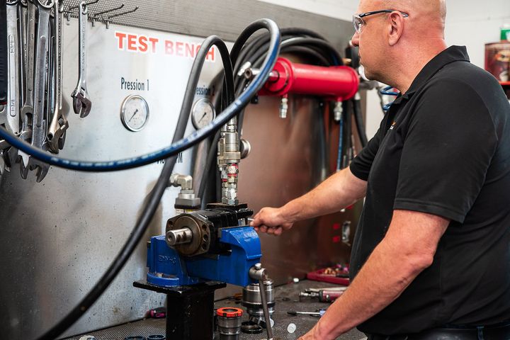 Un homme travaille sur une machine dans un garage.